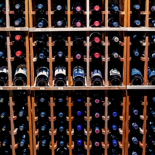 A large wooden wine rack filled with numerous bottles of red and white wine.