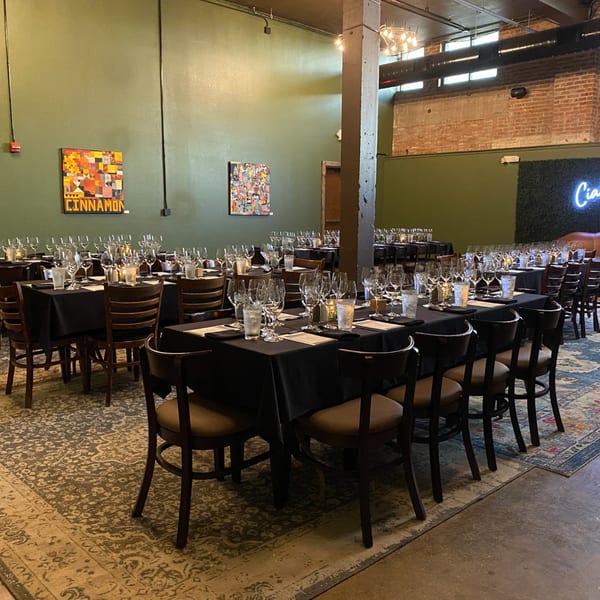 Pignetti's dining room set for an event with black-clothed tables, wine glasses, and candles.
